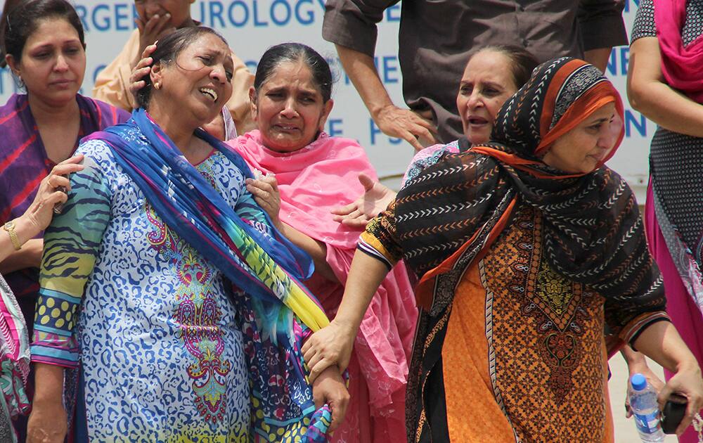 Women mourn as they visit a local hospital following an attack on a bus in Karachi, Pakistan.