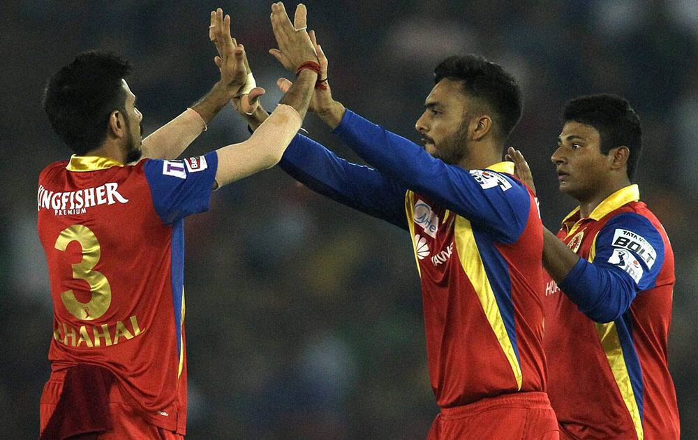 Yuzvendra Chahal of the Royal Challengers Bangalore congratulates Mandeep Singh of the Royal Challengers Bangalore for taking the catch to get Wriddhiman Saha of Kings XI Punjab wicket an IPL match in Mohali.