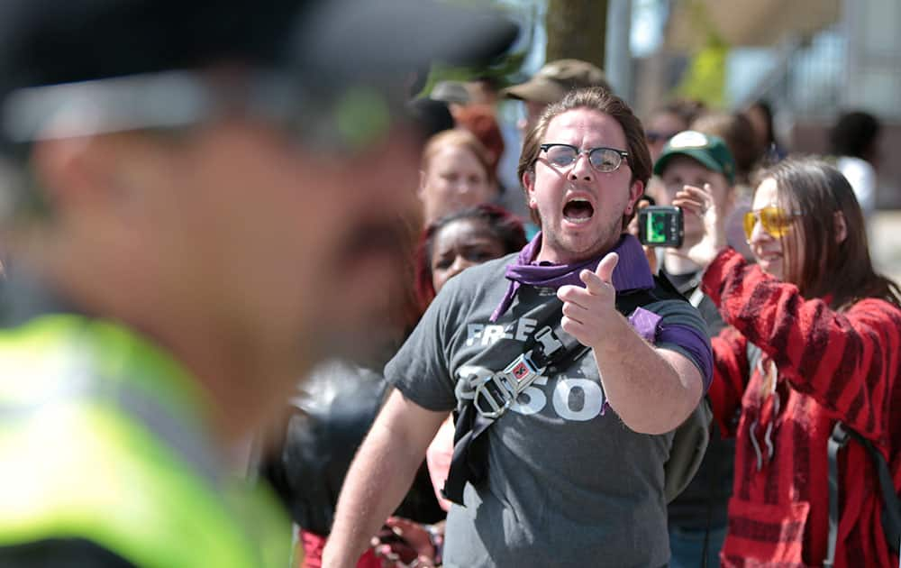 A protester yells at police as others are arrested during a protest in Madison, Wis.