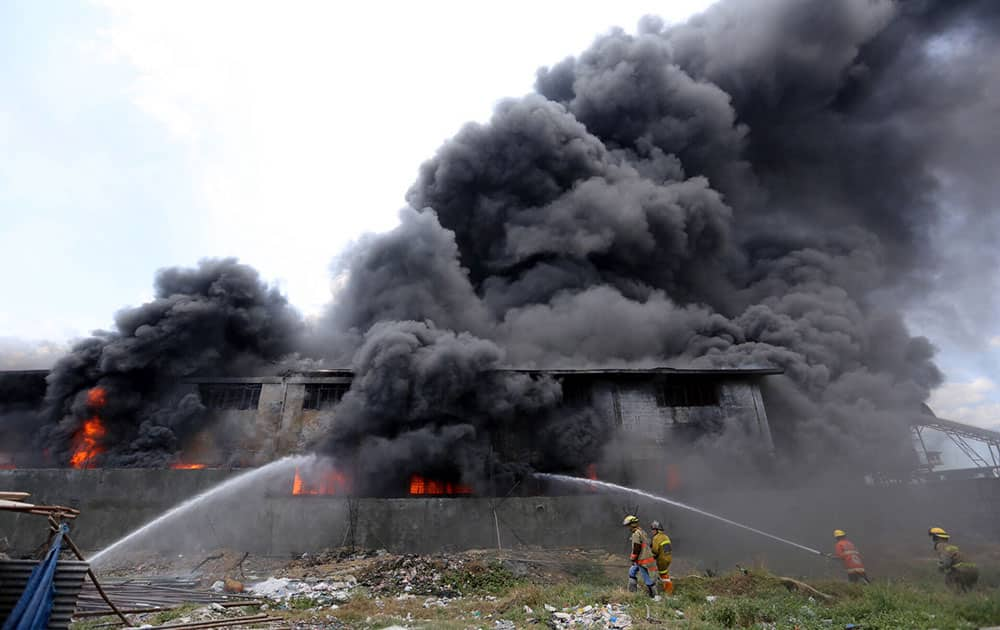 Firemen train their hoses at the burning Kentex footwear factory at Valenzuela city, a northern suburb in Manila, Philippines.