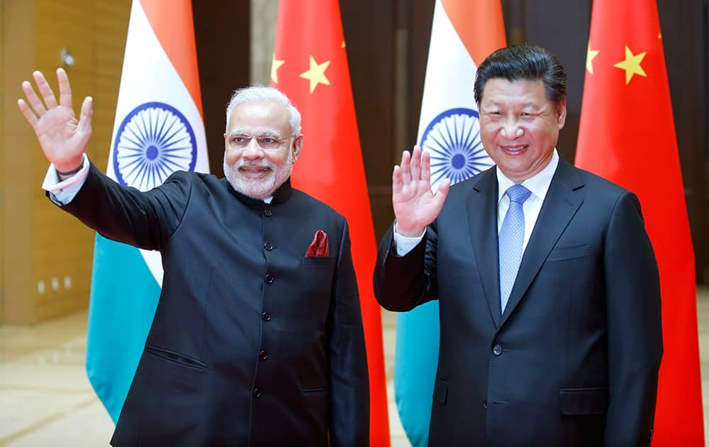 Prime Minister Narendra Modi and Chinese President Xi Jinping wave to journalists prior to their meeting in Xian, Shaanxi province, China.