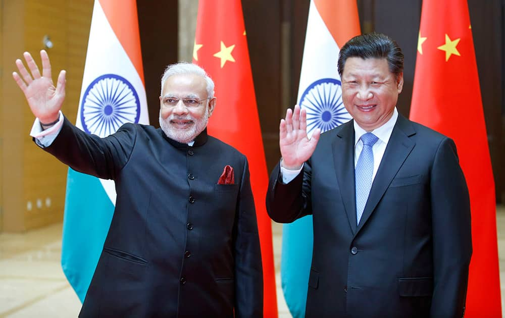 Prime Minister Narendra Modi and Chinese President Xi Jinping wave to journalists prior to their meeting in Xian, Shaanxi province, China.