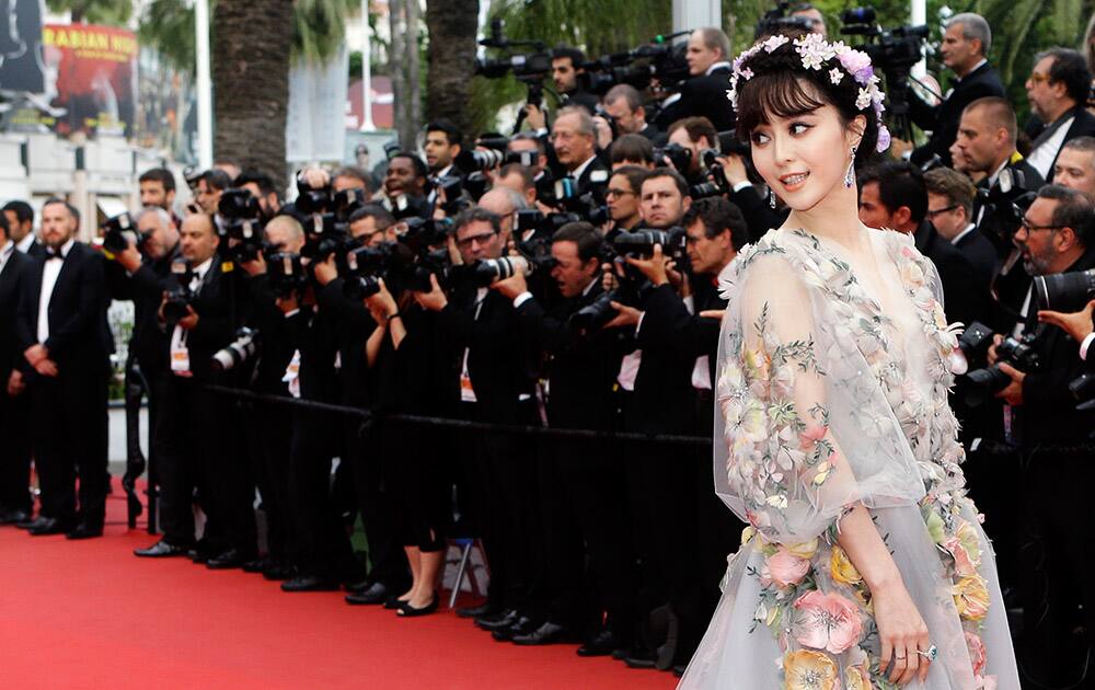 Actress Fan Bing Bing poses for photographers as she arrives for the screening of the film Mad Max: Fury Road at the 68th international film festival, Cannes.