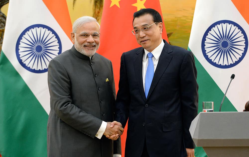 Prime Minister Narendra Modi shakes hands with Chinese Premier Li Keqiang during a press conference at the Great Hall of the People in Beijing, China .