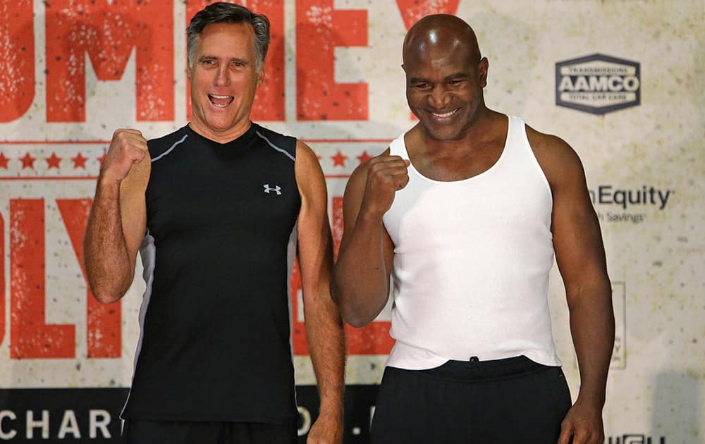 Former Republican presidential candidate Mitt Romney and five-time heavyweight boxing champion Evander Holyfield pose for a photo after an official weigh-in, in Holladay, Utah. Romney and Holyfield are set to square off at a charity fight on Friday, May 15, in Salt Lake City. 