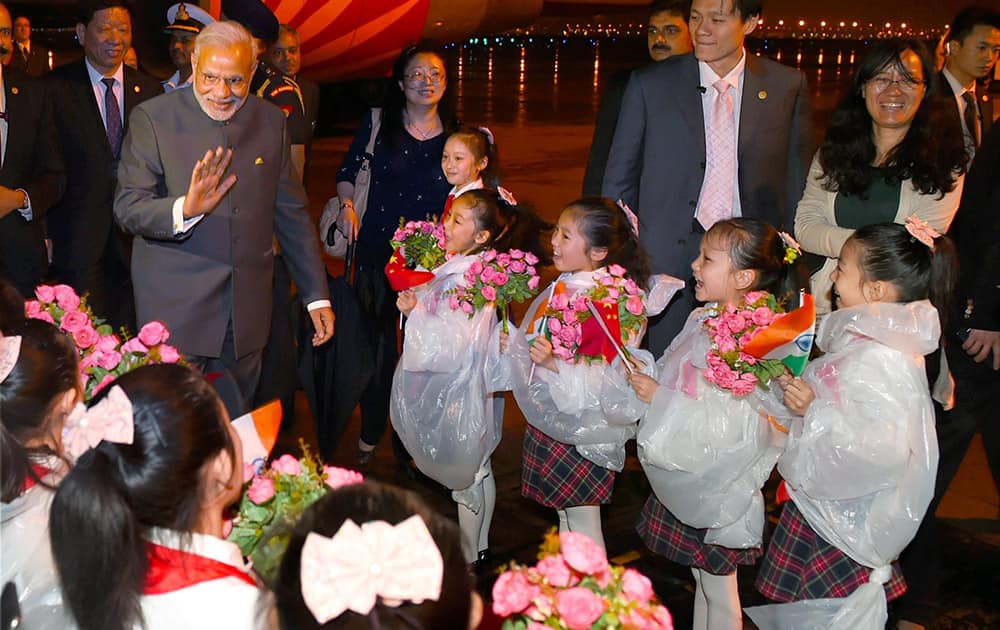 Prime Minister Narendra Modi being welcomed by children upon his arrival at Shanghai Honggiao International Airport in Shanghai.