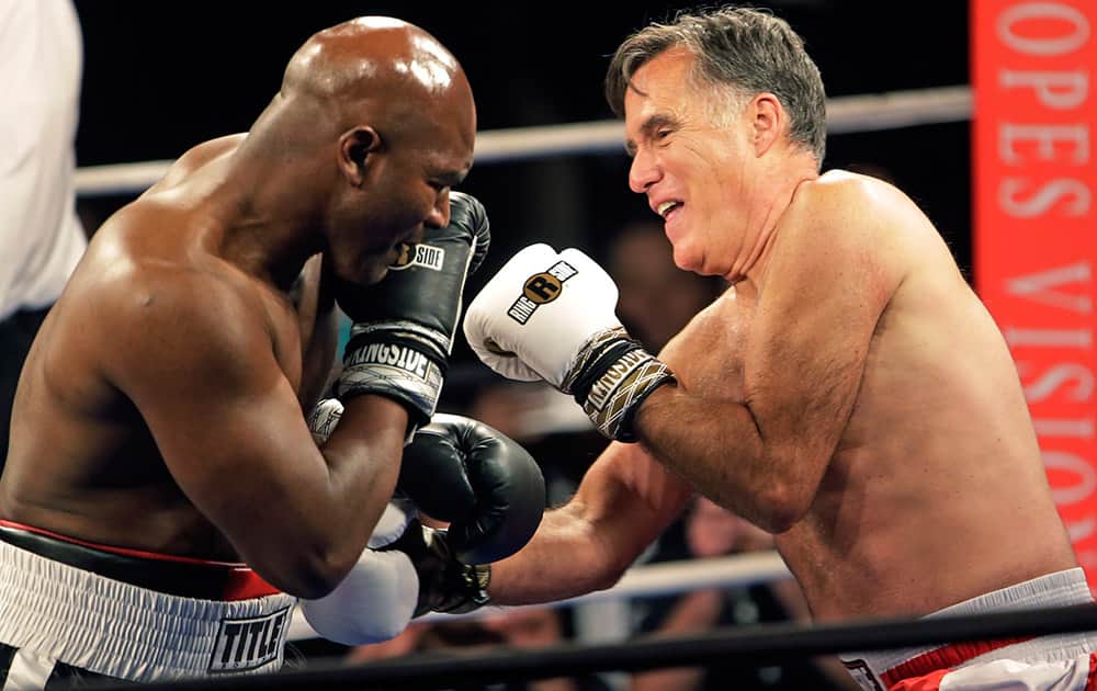 Former Republican presidential candidate Mitt Romney throws punches with five-time heavyweight boxing champion Evander Holyfield at a charity fight night event in Salt Lake City. The black-tie event will raise money for the Utah-based organization CharityVision, which helps doctors in developing countries perform surgeries to restore vision in people with curable blindness. 