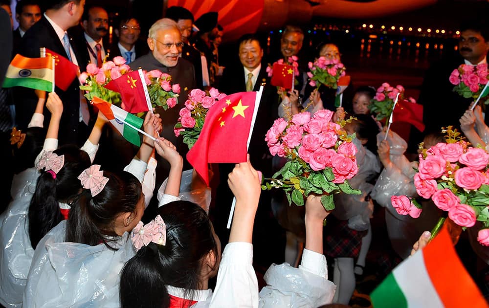 Prime Minister Narendra Modi being welcomed by children upon his arrival at Shanghai Honggiao International Airport in Shanghai.