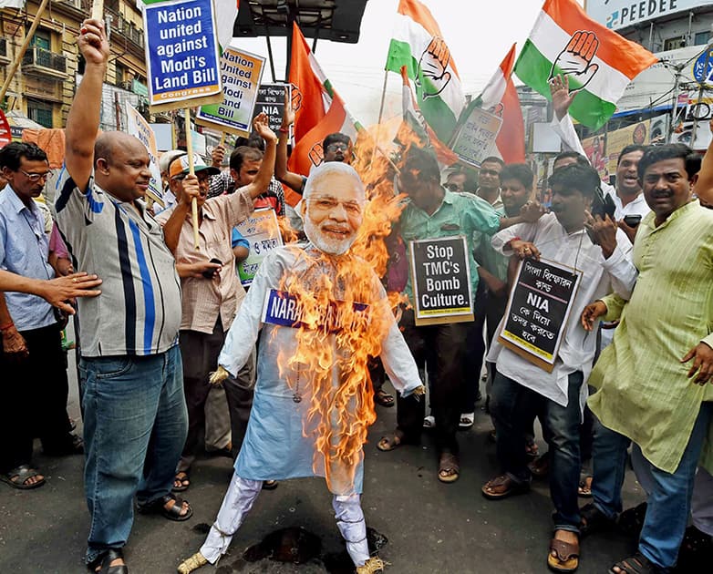 Congress activists burn an effigy of Prime Minister Narendra Modi during a protest against the Land Acquisition Bill in Kolkata on Saturday. They were also demanding NIA investigation into the Pingla.