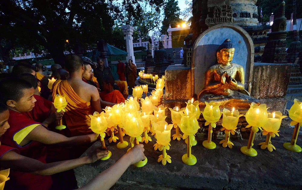 Buddhist monks and devotees light candles for Nepal earthquake victims at Mahabodhi temple in Bodhgaya.