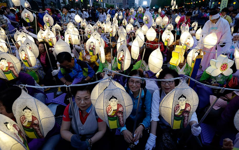 South Korean Buddhists holding lanterns take a rest after a parade during the Lotus Lantern Festival to celebrate the upcoming birthday of Buddha on May 25, on a street in Seoul, South Korea.