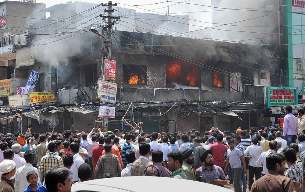 People gather after a fire broke out in a market in Faridabad.
