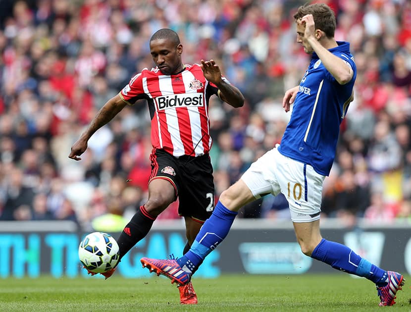 Sunderland's Jermain Defoe, left, vies for the ball with Leicester City's Andy King, right, during their English Premier League soccer match between Sunderland and Leicester City at the Stadium of Light, Sunderland, England.