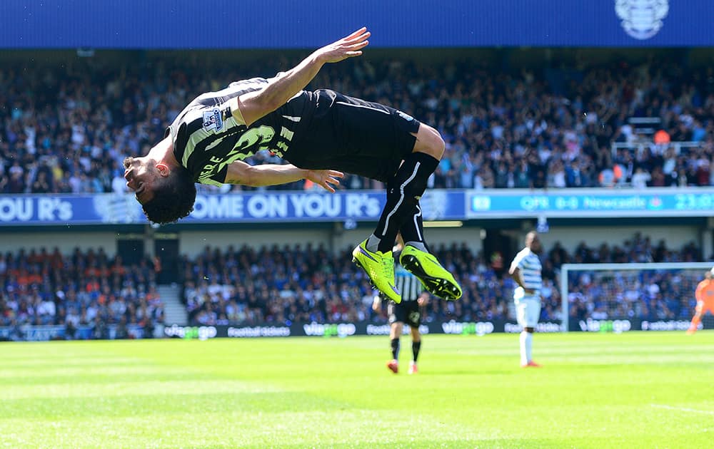 Newcastle United's Emmanuel Riviere does a backflip as he celebrates scoring his side's first goal, during their English Premier League soccer match against Queen's Park Rangers at Loftus Road, London.