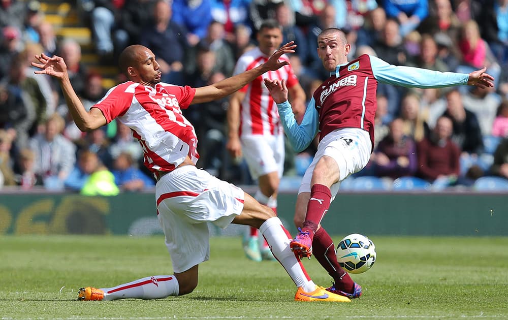 Stoke City's Steven N'Zonzi, left, and Burnley's David Jones compete for the ball during their English Premier League soccer match at Turf Moor, Burnley, England