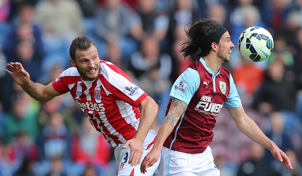 Stoke City's Erik Pieters, left, and Burnley's George Boyd battle for the ball during their English Premier League soccer match at Turf Moor, Burnley, England.