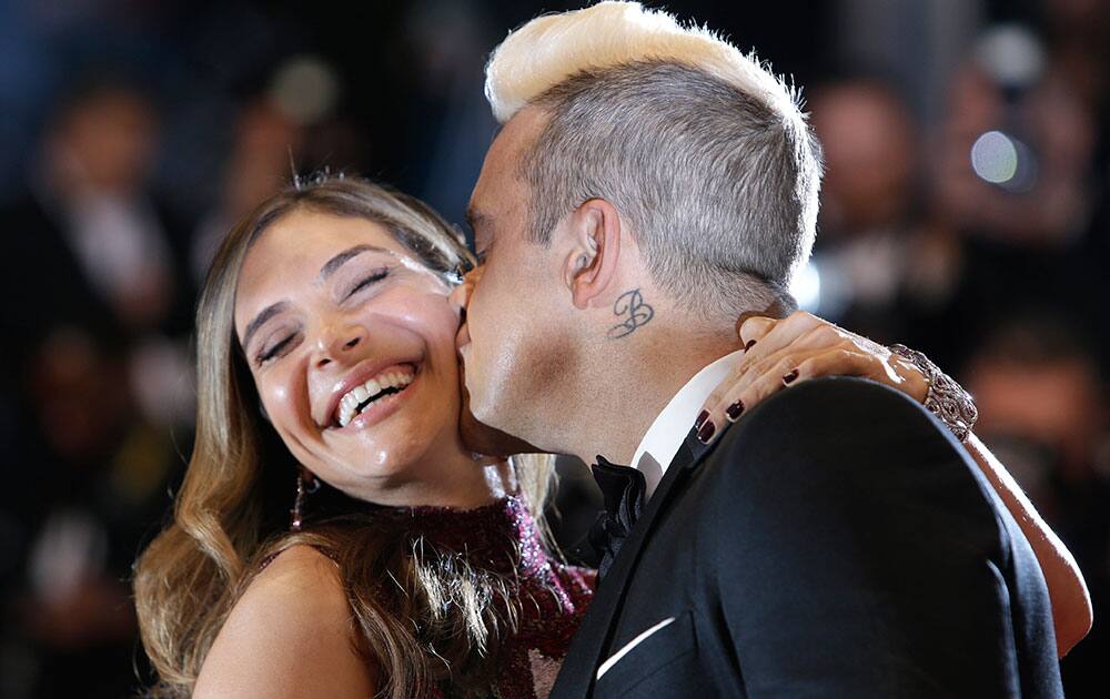 Singer Robbie Williams, right, kisses his wife Ayda Field as they pose for photographers upon arrival for the screening of the film The Sea of Trees at the 68th international film festival, Cannes.