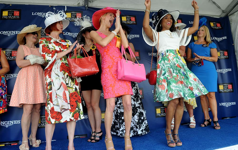 Katrina Dennis, right, of Baltimore, Md., celebrates after winning the Longines Most Elegant Woman at the Preakness contest.