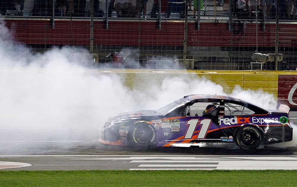 Denny Hamlin does a burnout after winning the NASCAR Sprint All-Star auto race at Charlotte Motor Speedway in Concord, N.C.