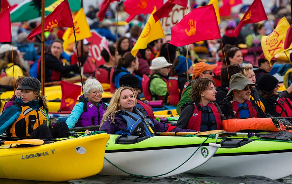 Activists tie up together in Elliott Bay as they join together in kayaks to protest the Polar Pioneer, Shell's giant oil rig, which is moored at the Port of Seattle's Terminal 5 during the 