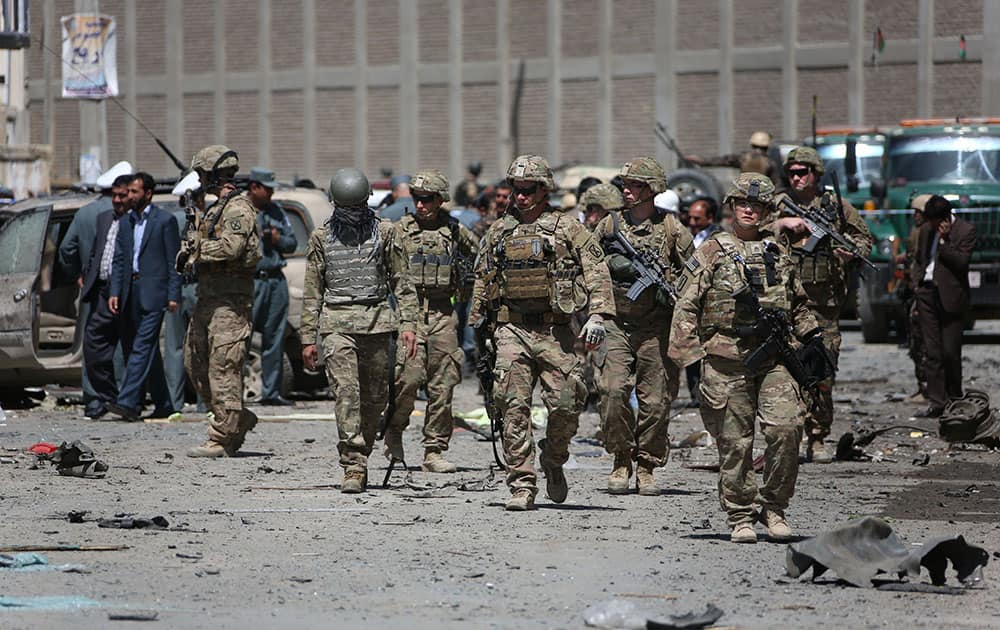 U.S. and Afghan security forces inspect the site of suicide attack near an international airport in Kabul, Afghanistan.