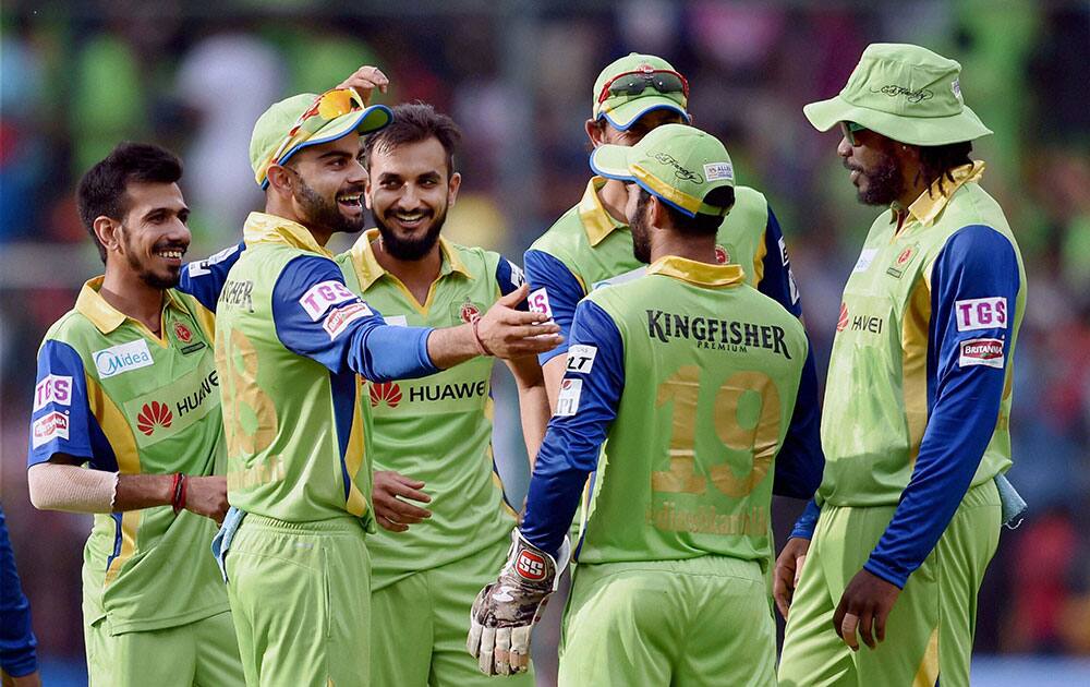 Royal Challengers Bangalore Harshal Patel with team mates celebrate the wicket of Kedar Jadhav during IPL8 match against Delhi Daredevils in Bengaluru.