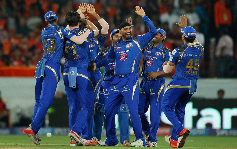 Mumbai Indians players Mitchell McClenaghan, Harbhajan Singh celebrate with team mates, after dismissal of Sunrisers Hyderabads batsman Eoin Morgan during the IPL match in Hyderabad.