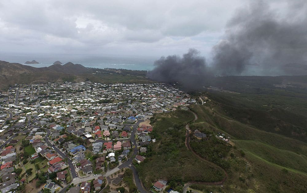 In this photo taken by a drone, smoke rises from a Marine Corps Osprey aircraft after it made a hard landing on Bellows Air Force Station near Waimanalo, Hawaii.