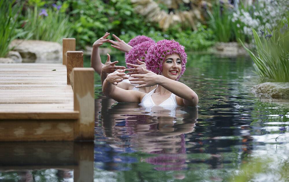 Synchronised swimmers pose for pictures in the swimming pond in the M & G Garden - The Retreat at the Chelsea Flower Show in London.