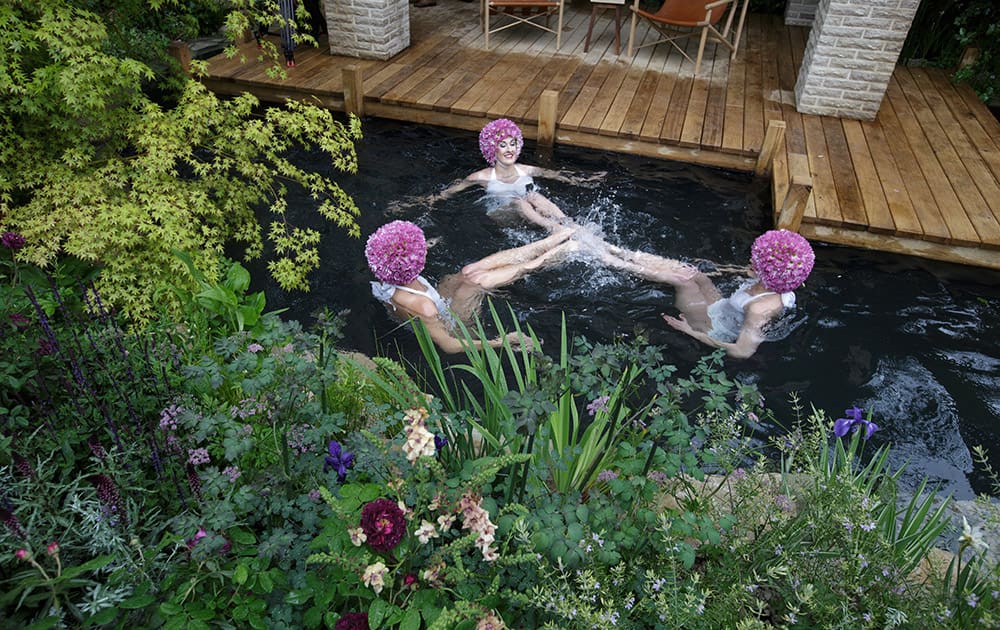 Synchronised swimmers pose for pictures in the swimming pond in the M & G Garden - The Retreat at the Chelsea Flower Show in London.