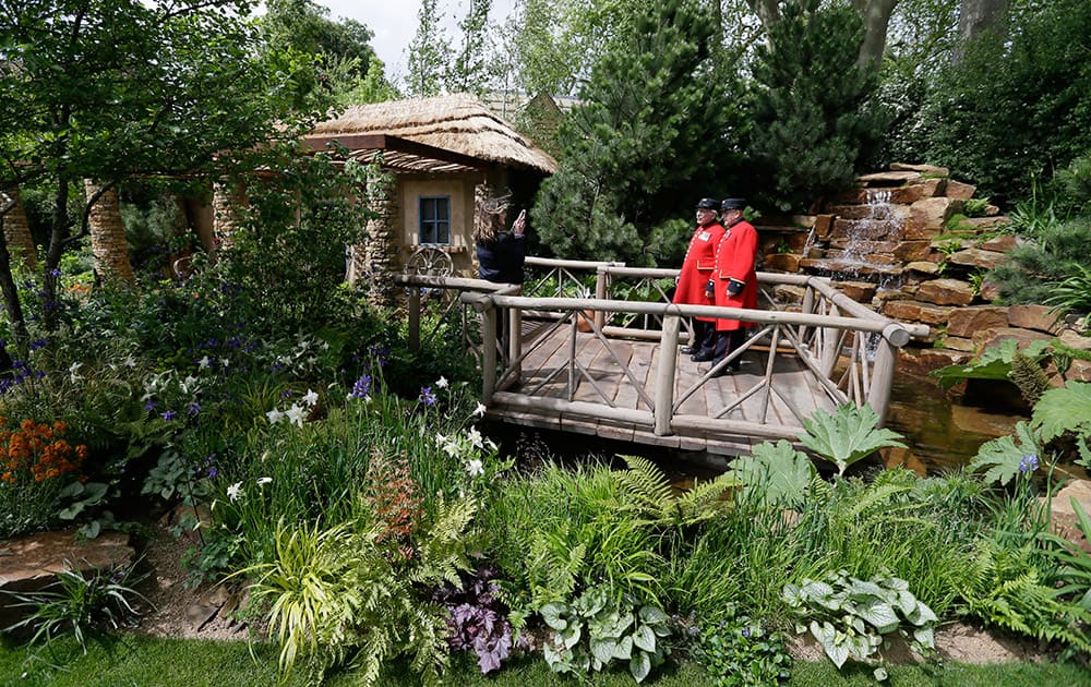 A person takes a picture of Chelsea Pensioners in the Sentebale - Hope in Vulnerability garden at the Chelsea Flower Show in London.