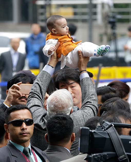 Prime Minister Narendra Modi, lifts a baby in South Korea as he visits the Cheonggye stream in Seoul, South Korea.