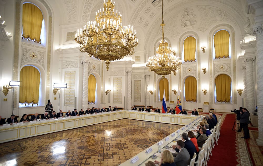 Russian President Vladimir Putin, center, between flags, chairs a meeting of the Council for Interethnic Relations and the Council for the Russian Language at the Kremlin in Moscow, Russia.