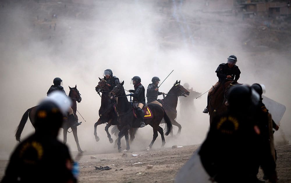 Mounted riot police clash with squatters during a land eviction in Lima Peru. On Monday hundreds of people squatted on land that according to the Ministry of Culture is an archaeological site. 