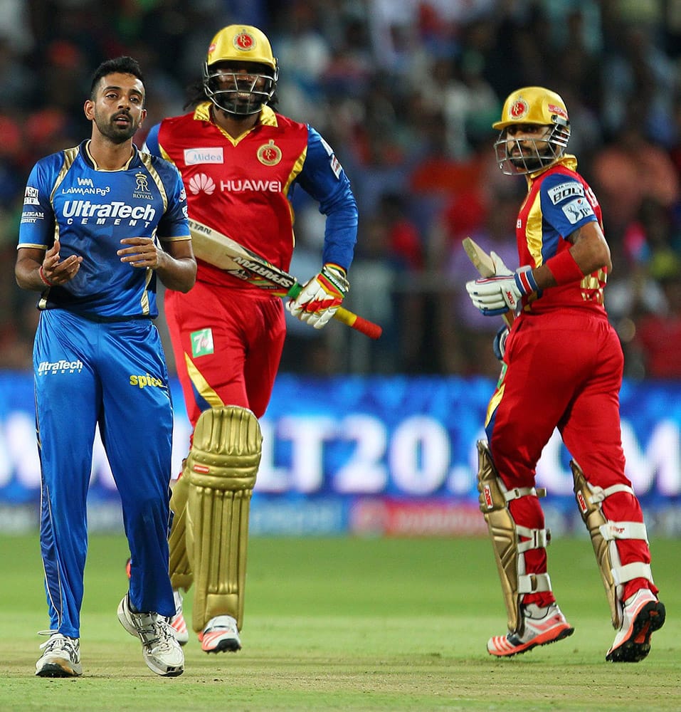 Dhawal Kulkarni of the Rajasthan Royals reacts as the ball doesnt carry to the fielder as batemen of Royal Challengers Bangalore Chris Gayle and Virat Kohli take a run during the eliminator match of the IPL in Pune.