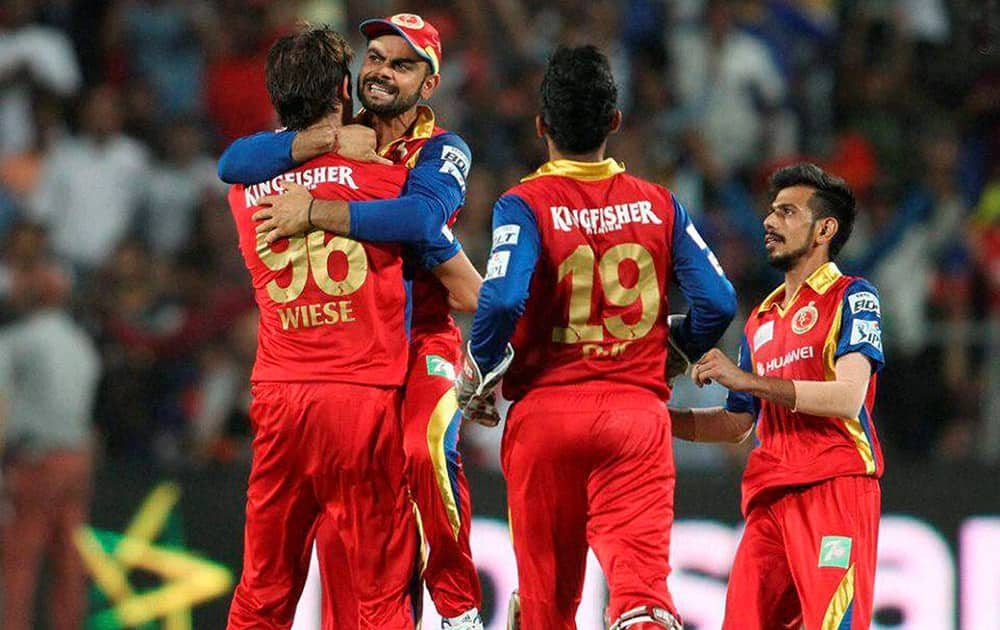 Royal Challengers Bangalore captain Virat Kohli congratulates David Wiese of the Royal Challengers Bangalore for getting Rajasthan Royals captain Steven Smith wicket during the eliminator match of the IPL 2015 at the MCA International Stadium in Pune.