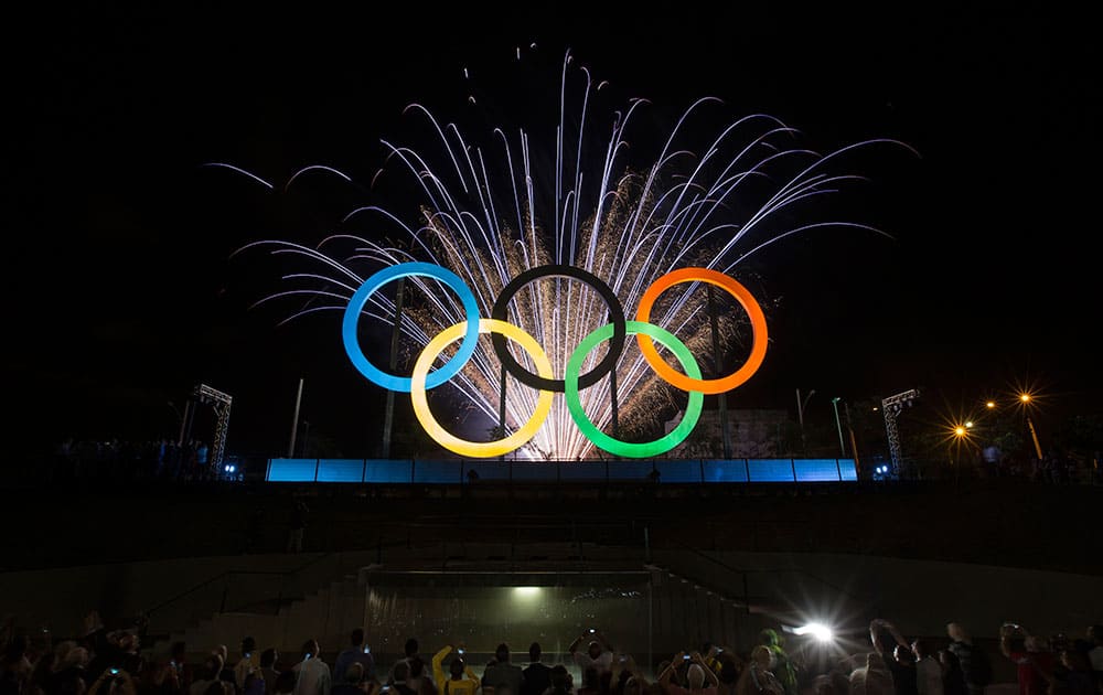 Fireworks explode behind the Olympic rings during their inauguration at the Madureira Park in Rio de Janeiro, Brazil.