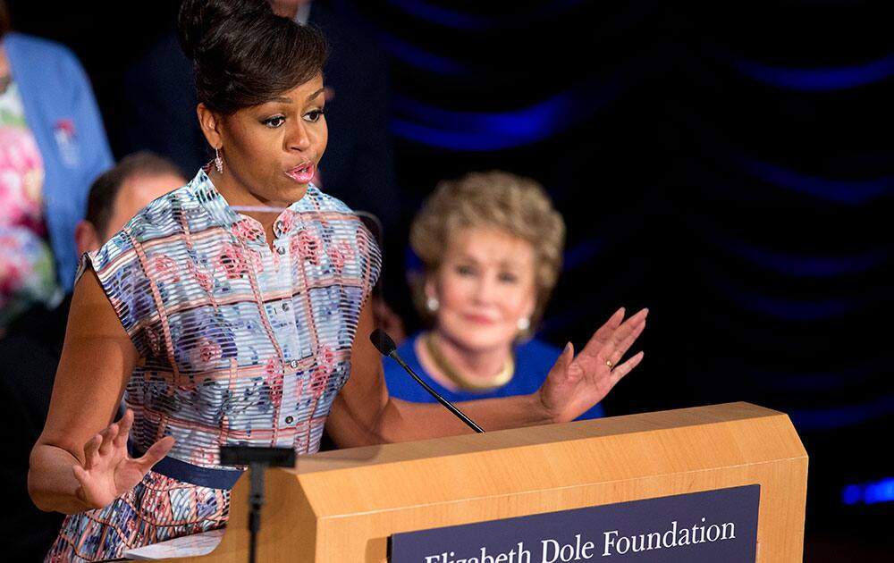 First lady Michelle Obama speaks at a gathering in Washington, joining former North Carolina Sen. Elizabeth Dole, right, Veterans Affairs Secretary Robert McDonald, and others for a Hidden Heroes Coalition Summit hosted by the Elizabeth Dole Foundation.