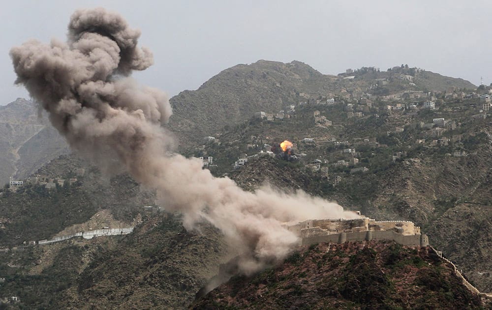 Smoke rises from al-Qahira castle, an ancient fortress that was recently taken over by Shiite rebels, as another building on the Saber mountain, in the background, explodes after Saudi-led airstrikes in Taiz city, Yemen