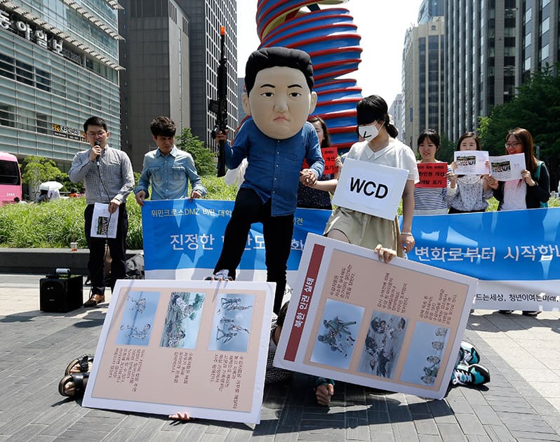 A South Korean university student, center left, wearing a mask of North Korean leader Kim Jong Un performs with his fellow student symbolizing the women activists of WCD, Women Cross DMZ, perform during a gathering to oppose the group's plans to march from North Korea to South Korea across the demilitarized zone, in Seoul, South Korea.