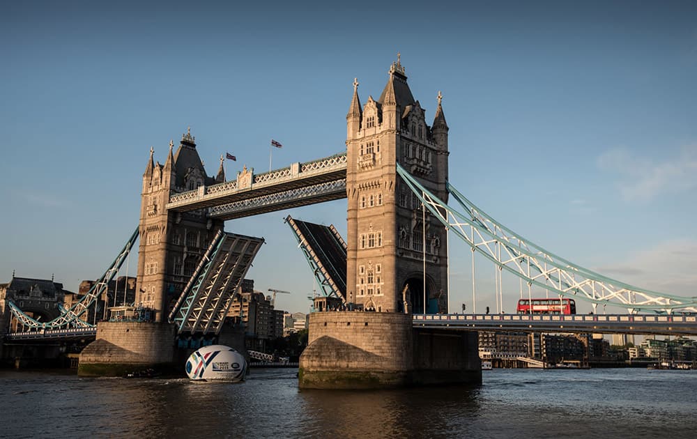 Land Rover floats a giant 8.2 metre high rugby ball along the Thames under Tower Bridge to reveal the bespoke Rugby World Cup 2015 Land Rover Defender which features a tailor-made display cabinet to showcase the Webb Ellis Cup, in London, England.