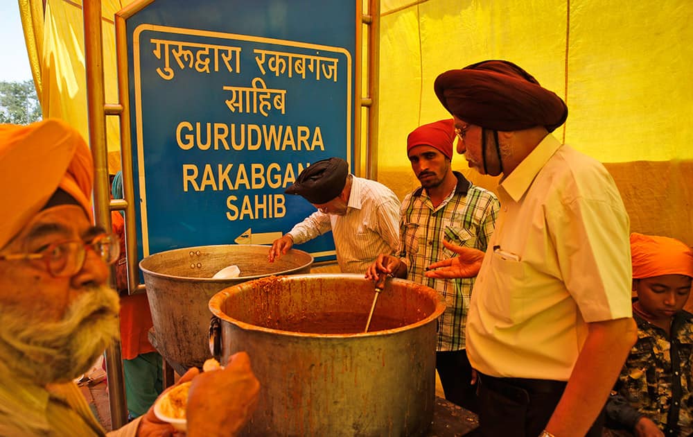 Sikhs distribute food to passersby to mark the martyrdom of Guru Arjan Dev in New Delhi.