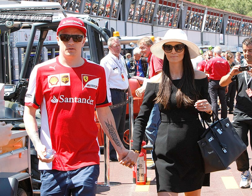 Ferrari driver Kimi Raikkonen of Finland walks with his partner Minttu Virtanenin after the autographs session at the Monaco racetrack, in Monaco.