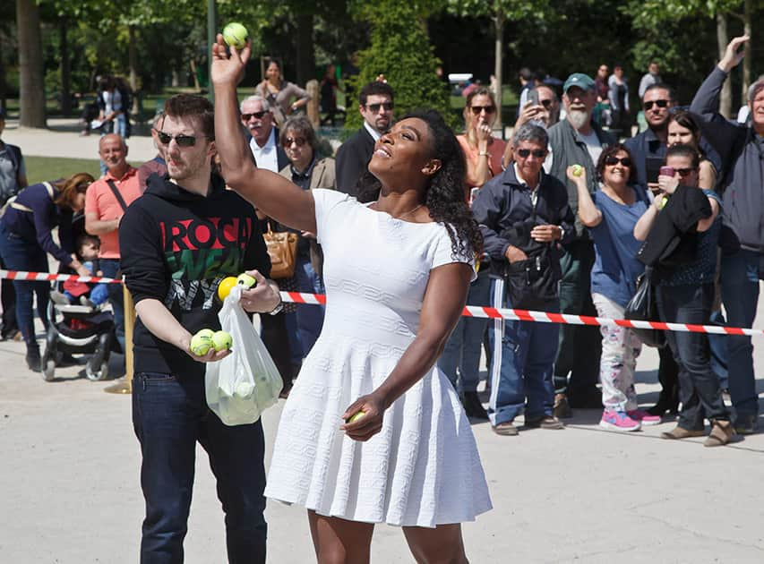 US tennis player Serena Williams, throws tennis balls to bysttanders during a photo call for the movie Pixels, directed by American Chris Colombus, near the Eiffel Tower in Paris, France