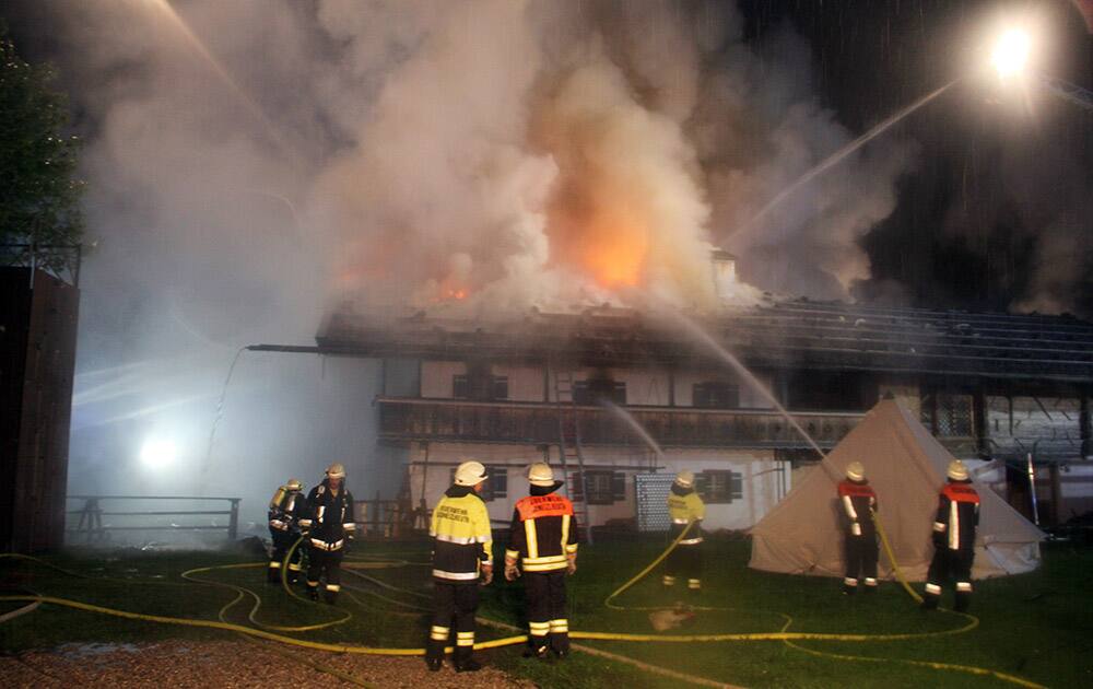 Firefighters try to extinguish a fire in the Bavarian town of Schneizlreuth , Germany.