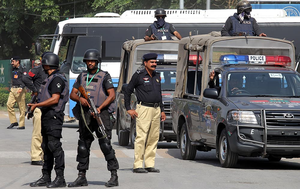 Pakistani police commandos stand alert as a bus carrying the Zimbabwe cricket team players arrives at the Gaddafi Stadium for a practice session in Lahore, Pakistan.