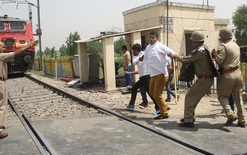 Police take away Gujjar community members who were trying to block railway tracks in Meerut to support their community agitating for resrvation in Rajasthan.