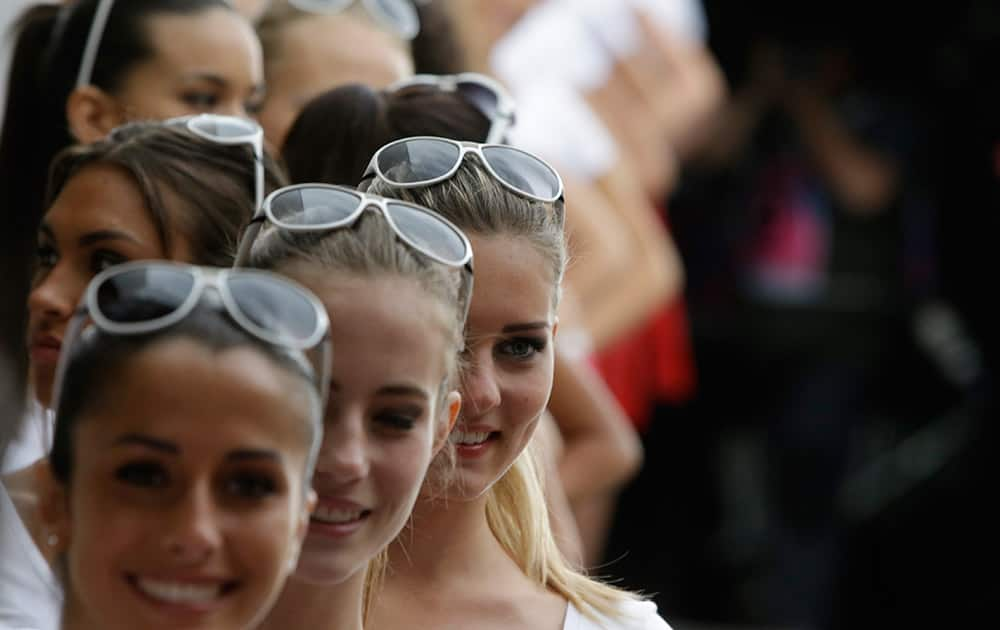 Models queue to enter for rehearsals on the starting grid after the qualifying session at the Monaco racetrack, in Monaco. The Formula one race will be held on Sunday. 