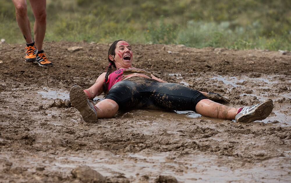 A participant lies in the mud as she takes part in the Mud Day athletic event in Toledo, Spain.