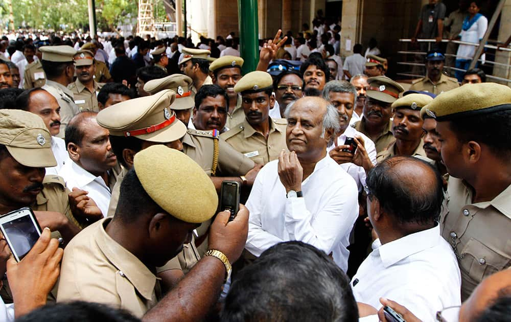 Fans and policemen surround south Indian film star Rajinikanth as he arrives to attend the swearing-in-ceremony of Jayaram Jayalalitha as the chief minister of Tamil Nadu state in Chennai.